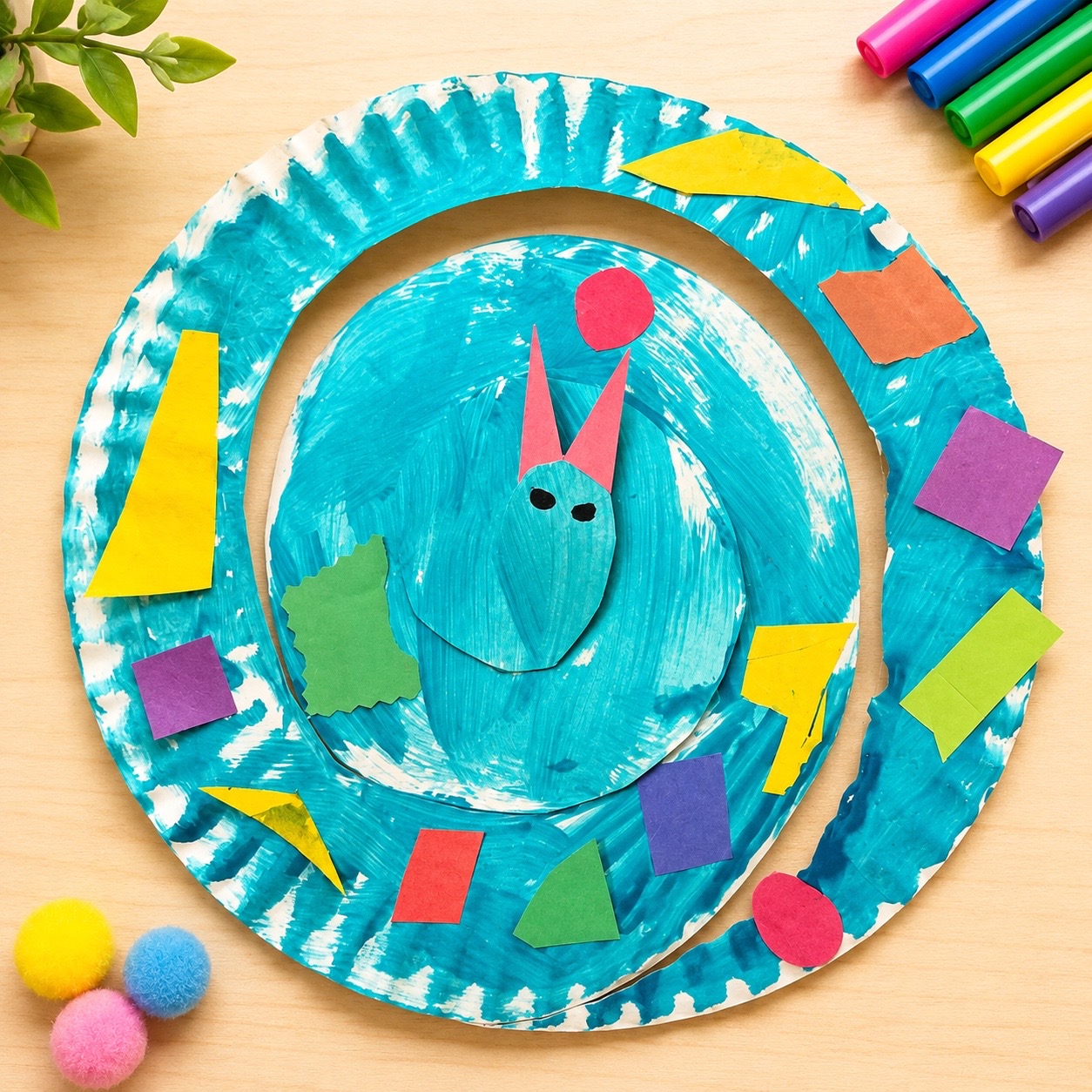 Colorful paper plate snake craft with painted body and paper shapes